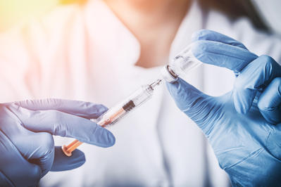 pharmacist holding needle and vaccine